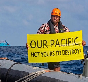 Victor Pickering, a Greenpeace activist from Fiji, in front of the Maersk Launcher, a ship chartered by DeepGreen. Photo: Supplied / Greenpeace