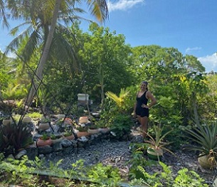 Kamoka Pearl co-owner Celeste Brash stands in front of a portion of the large garden that helps feed the farm crew. In soil made from bird droppings and coconut husks, they're attempting to grow everything from arugula and pineapples to taro and carrots in old broken buoys — all in an effort to be as self-sufficient as possible. Credit - Ashley Westerman/Courtesy The World