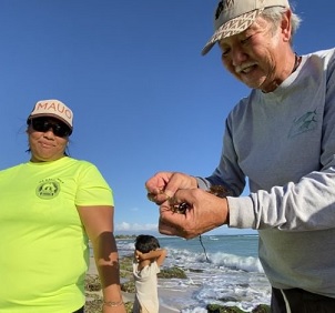 Limu Hui coordinator Wally Ito shows some limu to participants of the organization’s regular limu walks in Hawai‘i, which help locals connect with local seaweed species. Image by Kim Moa/KUA.