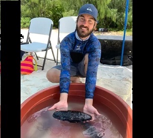 University of Guam Graduate Stiudent holds a sea cucumber at the Guam Wildlife Refuge's critter touch tanks exhibit. Credit - Anne Wen/PDN 