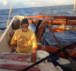 Steve aka ‘Steak’ carves up tuna for the crew of the Marumaru Atua, proving there is some fish out there? Credit - www.cookislandsnews.com