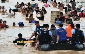 People wade in the chest deep floodwater in suburban Cainta, east of Manila, Philippines, in 2009. Such events will affect twice as many people by the end of the decade. Photograph: Pat Roque/AP