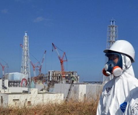 Workers stand in front of the Fukushima power plant in Japan months after a meltdown at the site. Cresit - Tom Gillespie, news.sky.com