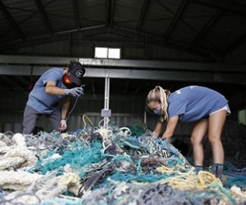 Hawaii Pacific University graduate student Drew McWhirter, left, and Raquel Corniuk, a research technician at the university's Center for Marine Debris Research, pull apart a massive entanglement of ghost nets on Wednesday, May 12, 2021 in Kaneohe, Hawaii. Credit - AP Photo/Caleb Jones.