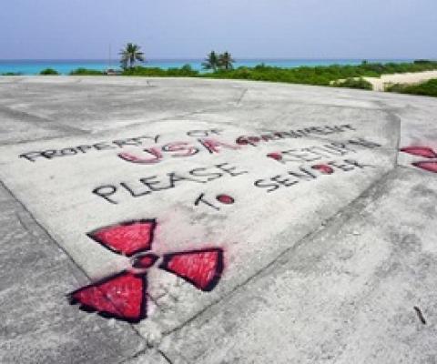Graffiti in May 2018 is written on Runit Dome, in Enewetak Atoll of the Marshall Islands, urging the United States to take responsibility for the radioactive waste encapsulated inside the concrete structure. (Mika Makelainen / Yle)