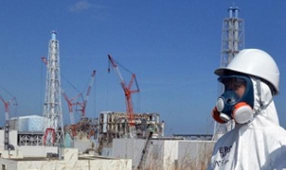 Workers stand in front of the Fukushima power plant in Japan months after a meltdown at the site. Cresit - Tom Gillespie, news.sky.com