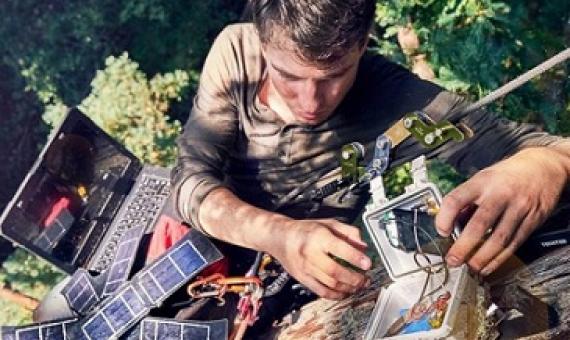 Topher White of Rainforest Connection installing a bioacoustic device in the forest canopy. Image by Ben Von Wong.